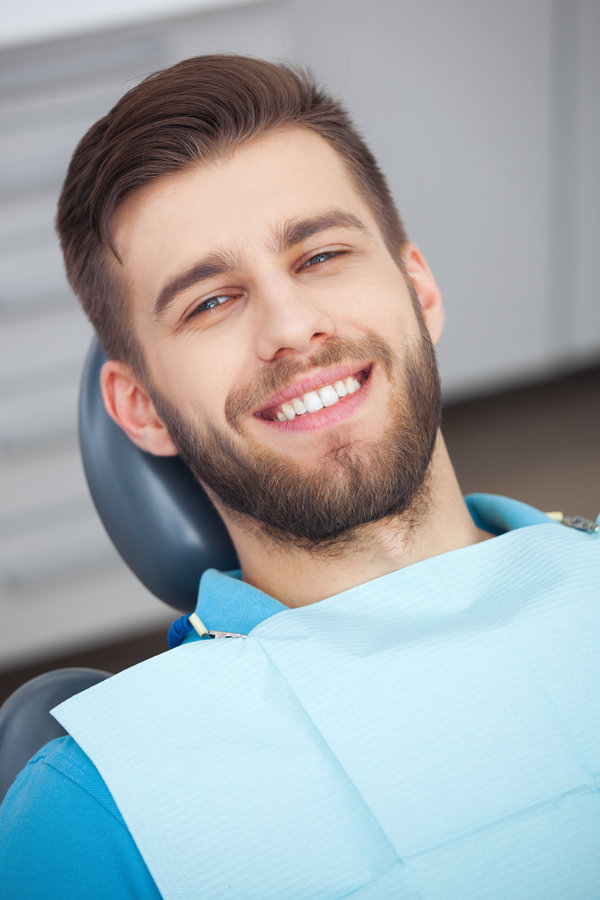 My smile is perfect! Portrait of happy patient in dental chair.