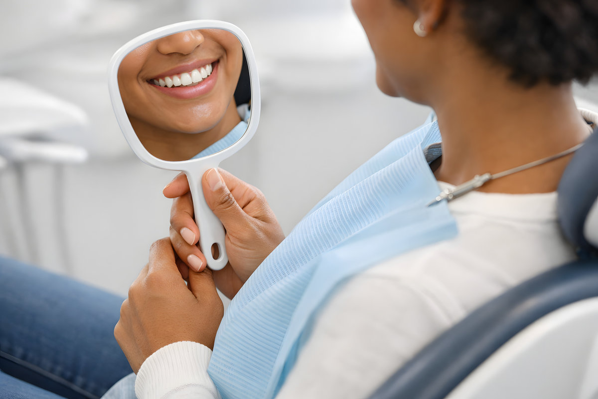 Dental Patient Admiring Their Smile in Handheld Mirror, Ethnically Diverse