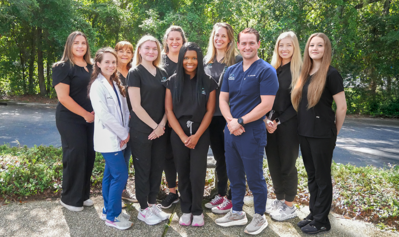 Coastal Cosmetic and Family Dentistry team standing together outdoors in front of trees