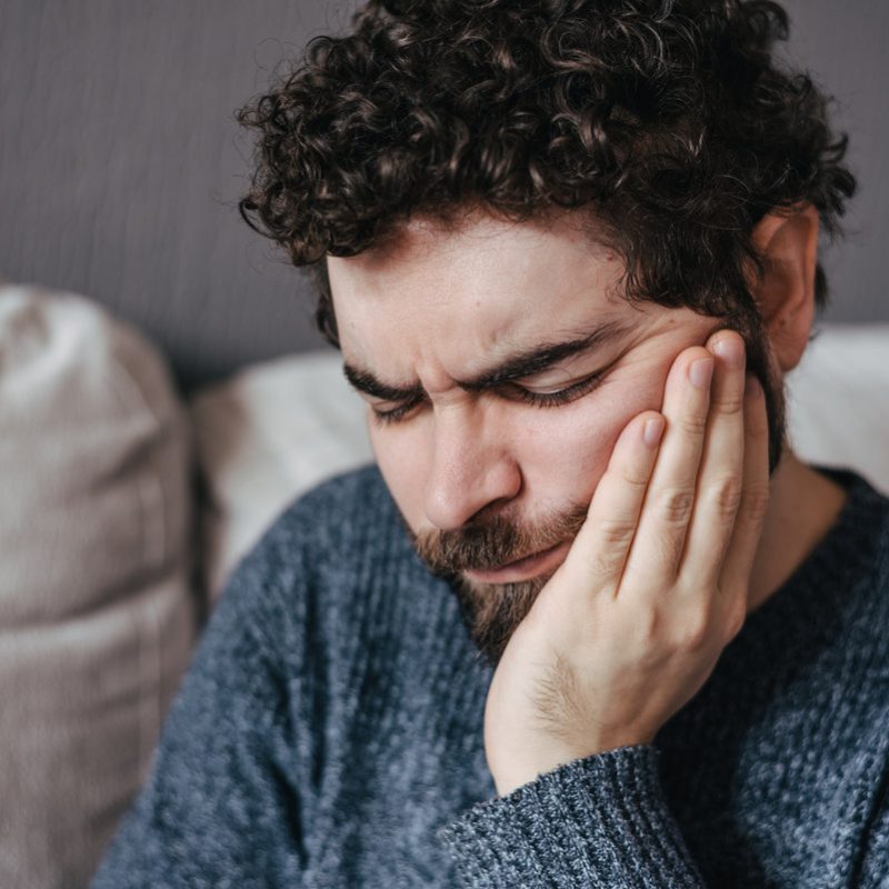 Man in pain suffering from toothache. Dental pain on teeth. Dentist